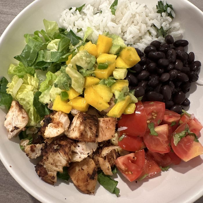 Chicken salad bowl with black beans, mango and avocado salsa and cilantro lime rice