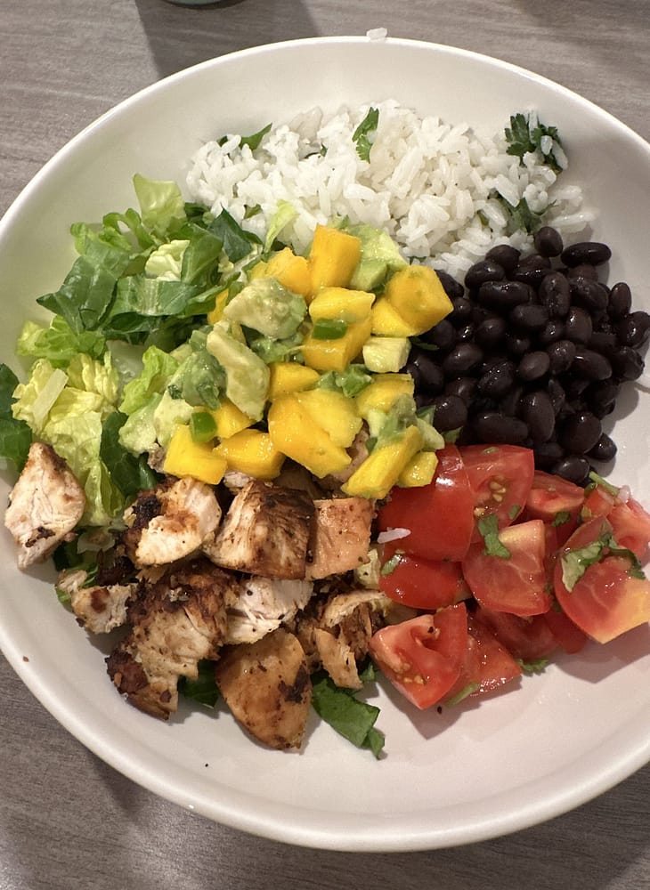 Chicken salad bowl with black beans, mango and avocado salsa and cilantro lime rice